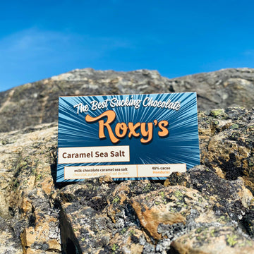 Caramel Sea Salt 48% Milk Bar on a rock with blue sky in the background