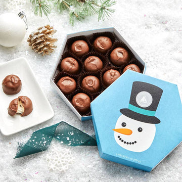 Snowman Milk Chocolate Marshmallows - 12 pc on a bed of snow with some Christmas decor